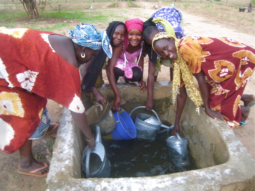 Cooperative members collect water from a cistern in Diender.
