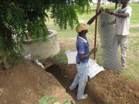 Volunteers dig the trench so that it drains into an abandoned well.