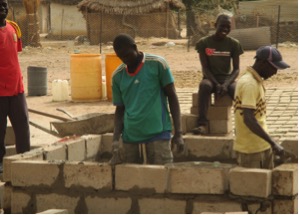 A mason, Mame Fall is currently helping to build a platform for the water reservoir near the site for the new cooperative garden in Walo