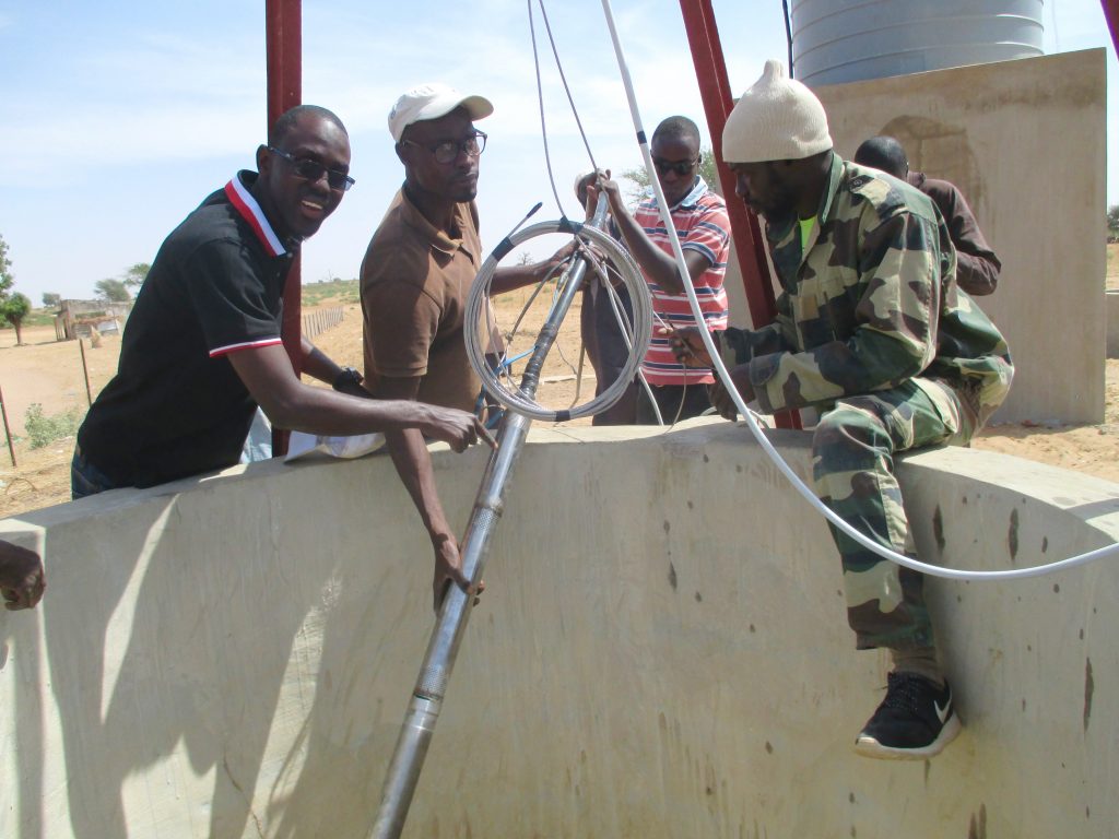 Volunteers install the solar powered pumping system